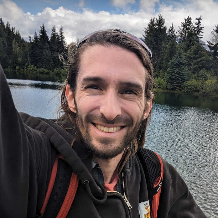 smiling guy in front of a lake